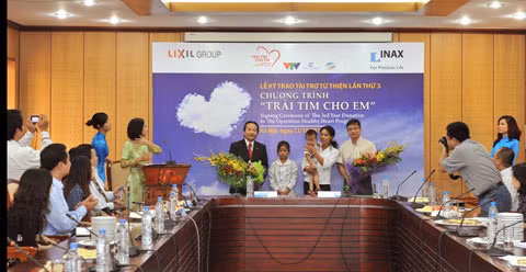 Gia đình các cháu được chương trình tài trợ mổ tim tặng hoa cảm ơn nhà tài trợ và đại diện Quỹ "Tấm lòng Việt".