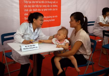 Một bác sỹ thuộc Viện Dinh dưỡng Quốc gia đang khám cho các bé.