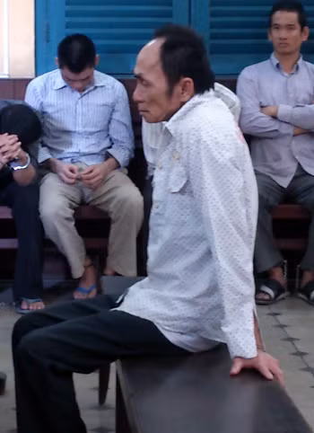 Chú thích ảnh: vì đang bệnh nặng nên bị cáo Tiếng phải dùng tay vịn ghế mới ngồi vững.