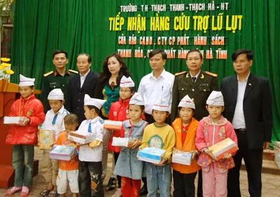Thượng tá Hà Thế Cương, đại diện Báo CAND và các nhà hảo tâm tặng vở viết cho các em học sinh Trường Tiểu học Thạch Thanh, tỉnh Hà Tĩnh.