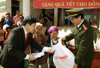 Đại tá - Nhà thơ Hồng Thanh Quang, Phó Tổng Biên tập Báo CAND cùng đại diện Ngân hàng TMCPCTVN trao quà cho đồng bào Tây Nguyên.