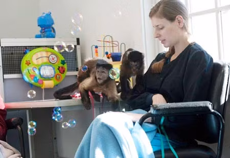 Alison Payne, Giám đốc Đào tạo trường Monkey College, chụp ảnh với hai con khỉ Capuchin.