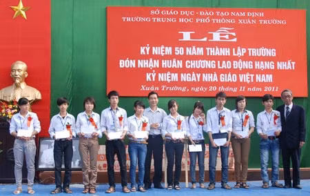 Đại tá Phạm Văn Miên, phó TBT Báo CAND và đại diện công ty Tân Việt Bắc trao học bổng cho các em học sinh nghèo vượt khó.