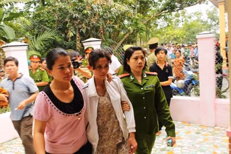 Hung thủ Trương Thị Kiều Phương (giữa) được áp giải đến hiện trường.