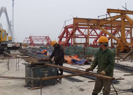 Công nhân làm việc ngày đầu xuân ở công trường cầu Nhật Tân.