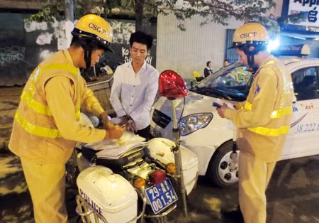 CSGT đang lập biên bản xử lý lái xe taxi vi phạm giao thông.