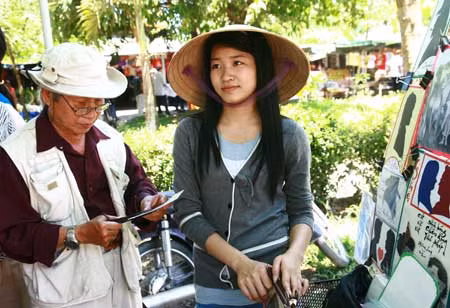 Ông Long đang cắt hình cho một cô gái.
