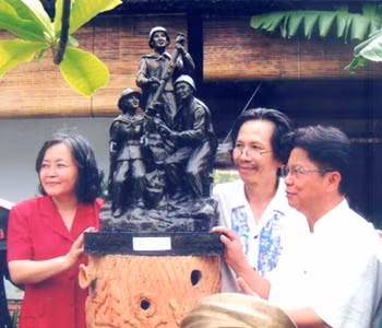 Vợ chồng nghệ sĩ Nguyễn Sang - Kim Thanh và người thân bên phác thảo tượng đài Liệt sĩ Trường Sơn.
