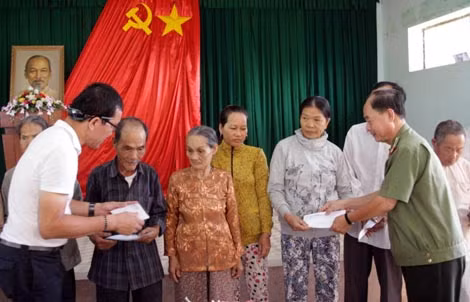 Đại tá Trần Kim Thẩm và ông Lâm Tấn Lợi tặng quà cho bà con xã Tịnh Minh - Tịnh Bắc.