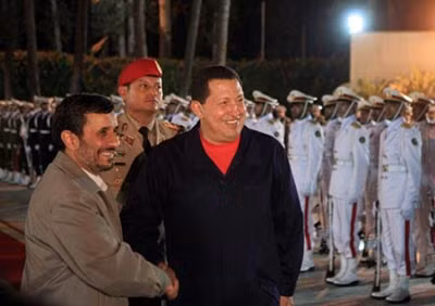 Tổng thống Iran Mahmoud Ahmadinejad được Tổng thống Venezuela Hugo Chavez đón tiếp ngay khi vừa xuống sân bay ở Caracas. Ảnh: AFP.