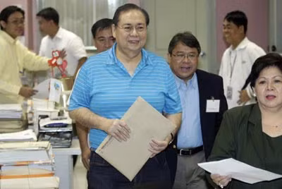 Ông Mike Arroyo (áo xanh ở giữa) đã được tại ngoại chỉ vài giờ sau khi tòa án Sandiganbayan ban lệnh bắt giữ vợ chồng ông. Ảnh: AP.