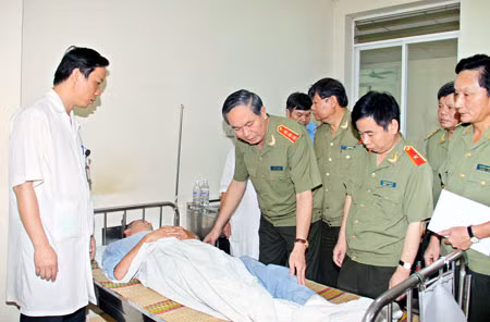 Thượng tướng Trần Đại Quang, Ủy viên Bộ Chính trị, Bộ trưởng Bộ Công an thăm hỏi, tặng quà một cán bộ Công an bị thương trong khi truy bắt tội phạm ma tuý. Ảnh Công Gôn.