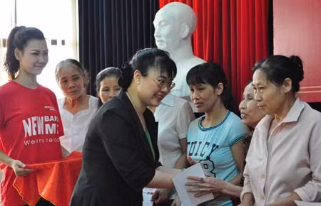 Bà Nguyễn Thị Nguyệt Hường trao sổ tiết kiệm cho phụ nữ nghèo ở quận Tây Hồ (Hà Nội).