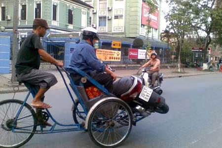 Sau khi dập lửa, chiếc xe máy được ông Tuấn đưa lên xe xích lô chở tới tiệm sửa.