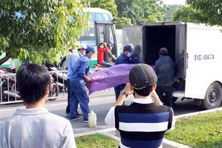 Người dân hiếu kỳ đứng thẽo dõi vụ việc. Thi thể người phụ nữ được đưa ra khỏi hiện trường.