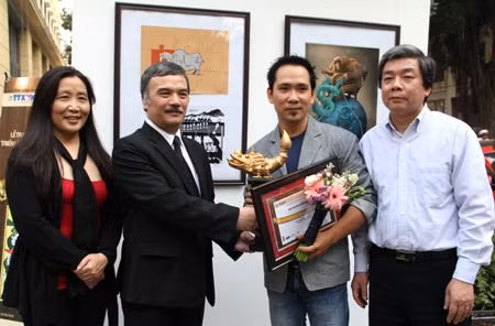 Ông Hà Minh Huệ - Phó Chủ tịch thường trực Hội Nhà báo Việt Nam, ông Nguyễn Hoài Dương, Phó Tổng Giám đốc TTXVN và bà Trương Lê Kim Hoa - Trưởng BTC giải, TBT báo TT&Văn hóa trao giải Nhất cho Họa sĩ Trần Hải Nam. Bức tranh đoạt giải Nhất.