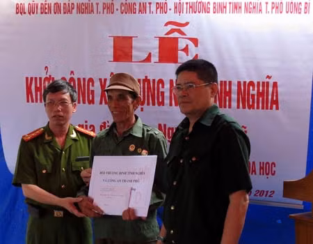 Đại diện lãnh đạo Công an TP Uông Bí trao tiền từ thiện cho gia đình chính sách.