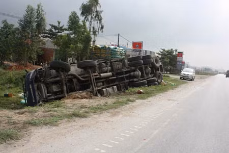 Xe tải lật nghiêng bên vệ đường, 15 tấn ngô đổ vung vãi.