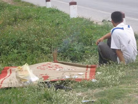Người con trai đau đớn bên thi thể người cha xấu số.
