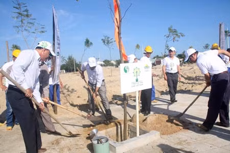 Lãnh đạo TP Hội An và đại diện Công ty CP Sữa Việt Nam Vinamilk cùng nhau trồng những cây xanh đầu tiên trong số 25.500 cây xanh sẽ trồng tại TP Hội An. Ảnh chụp sáng 25/11.