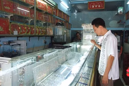 Tại TP HCM, mặc dù giá vàng liên tục biến động nhưng tình trạng mua bán vẫn trầm lắng. Giá vàng tăng cao sẽ ít nhiều tác động đến những mặt hàng thiết yếu. Ảnh minh họa.