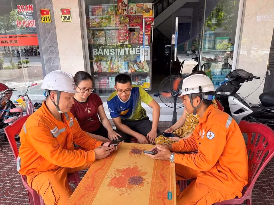 Nhân viên Điện lực Đông Triều, CTĐL Quảng Ninh tuyên truyền, hướng dẫn khách hàng cài đặt ứng dụng EVN CSKH.