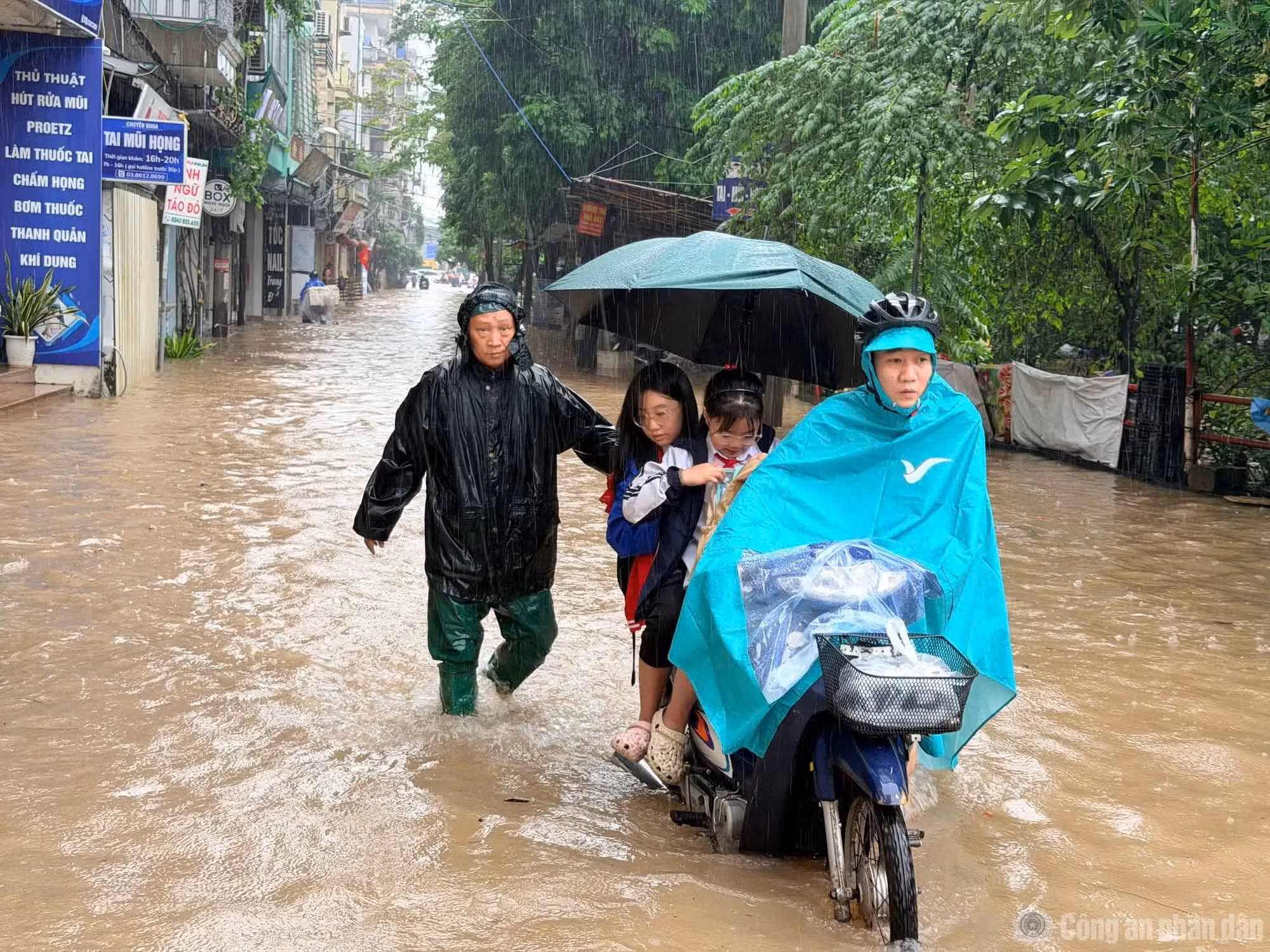 Người dân di chuyển khó khăn qua tuyến đường bị ngập sâu. Ảnh: Bảo Châu