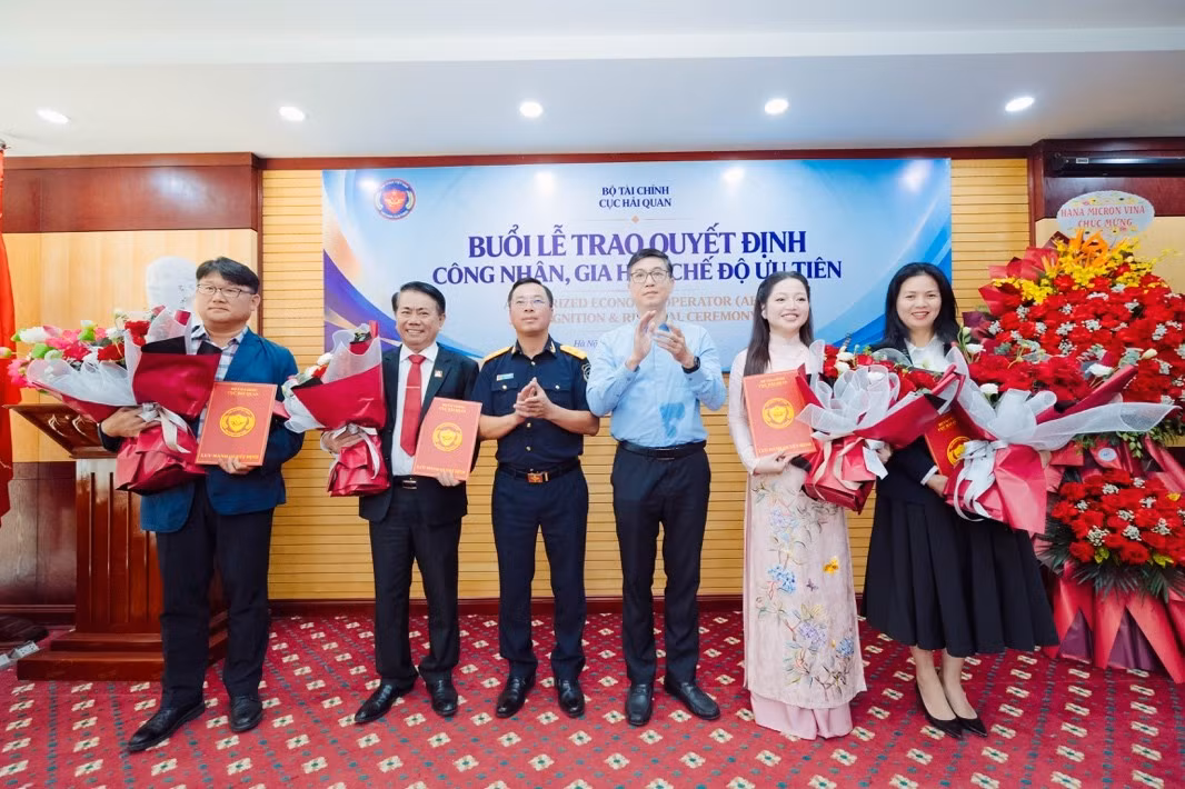 Phó Cục trưởng Cục Hải quan Trần Đức Hùng (thứ 3 bên trái sang) và Phó Cục trưởng Cục Đầu tư nước ngoài (Bộ Tài chính) Trương Minh trao quyết định gia hạn và tặng hoa cho 4 doanh nghiệp. Ảnh: Cục Hải quan.