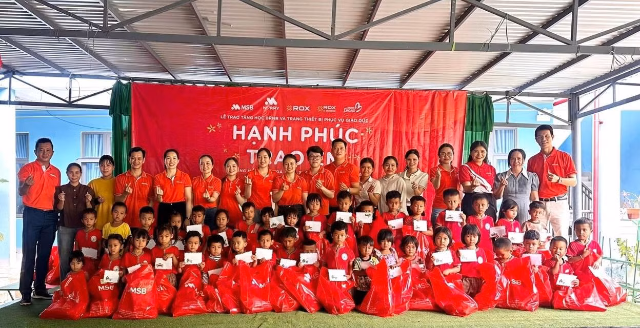 Các em nhỏ nhận quà và học bổng từ chương trình.