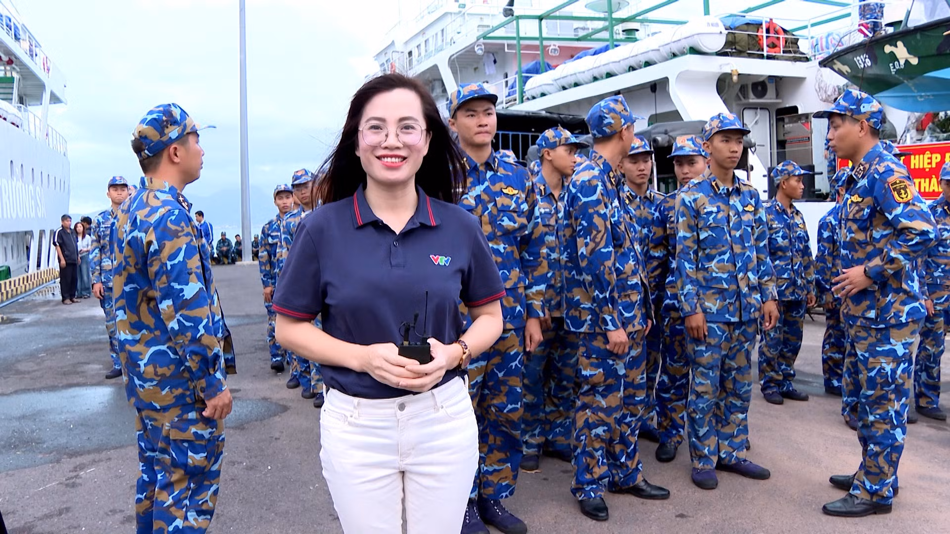Nhà báo Lê Hương (VTV8 - Đài Truyền hình Việt Nam) tác nghiệp trên cầu cảng Cam Ranh trước khi xuống tàu 571.