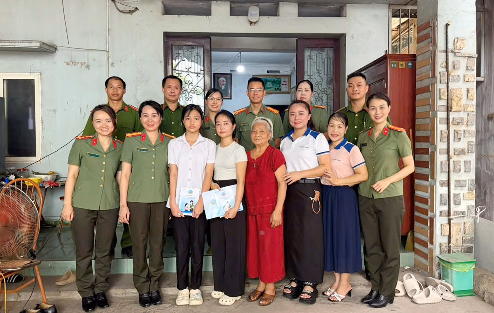 Hội Phụ nữ Cục Truyền thông CAND cùng đại diện Công an địa phương, Ban Giám hiệu trường THCS Nha Trang chụp ảnh lưu niệm cùng gia đình em Trần Hồng Ngọc.