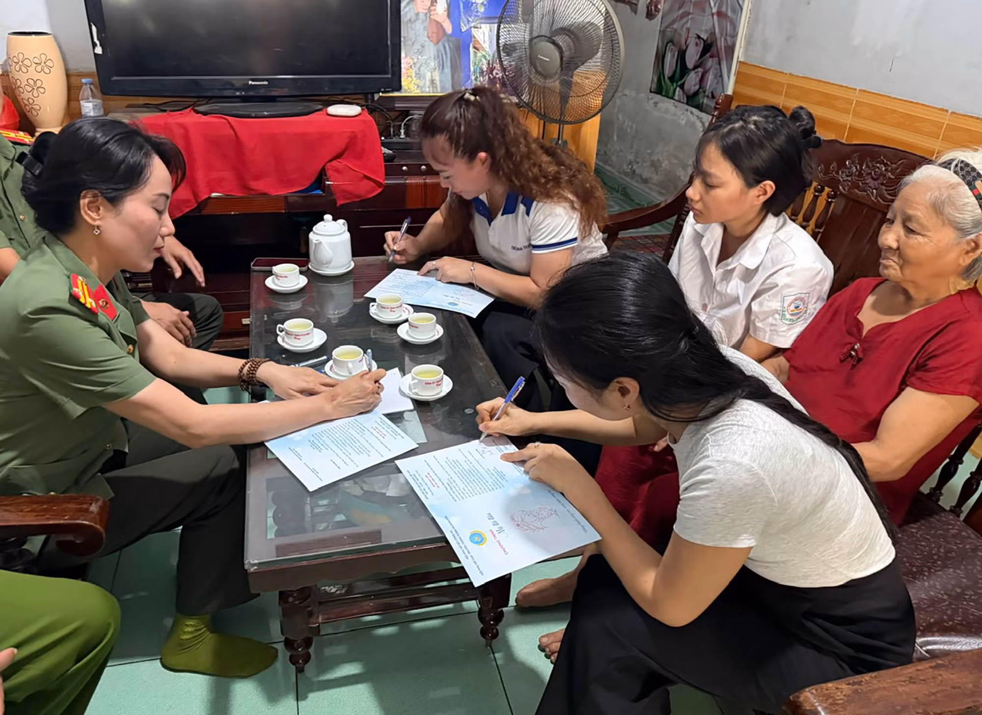 Đại diện Hội Phụ nữ Cục Truyền thông CAND, gia đình em Trần Hồng Ngọc và Công an phường Phan Đình Phùng thực hiện ký kết giao ước nhận đỡ đầu ba bên.
