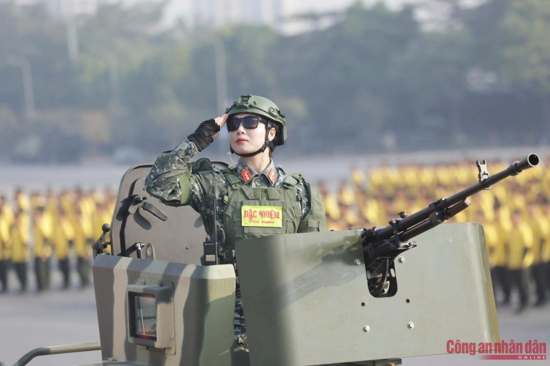 Nữ chiến sĩ CAND chào nghiêm trang từ một xe bọc thép hiện đại của lực lượng Cảnh sát đặc nhiệm.