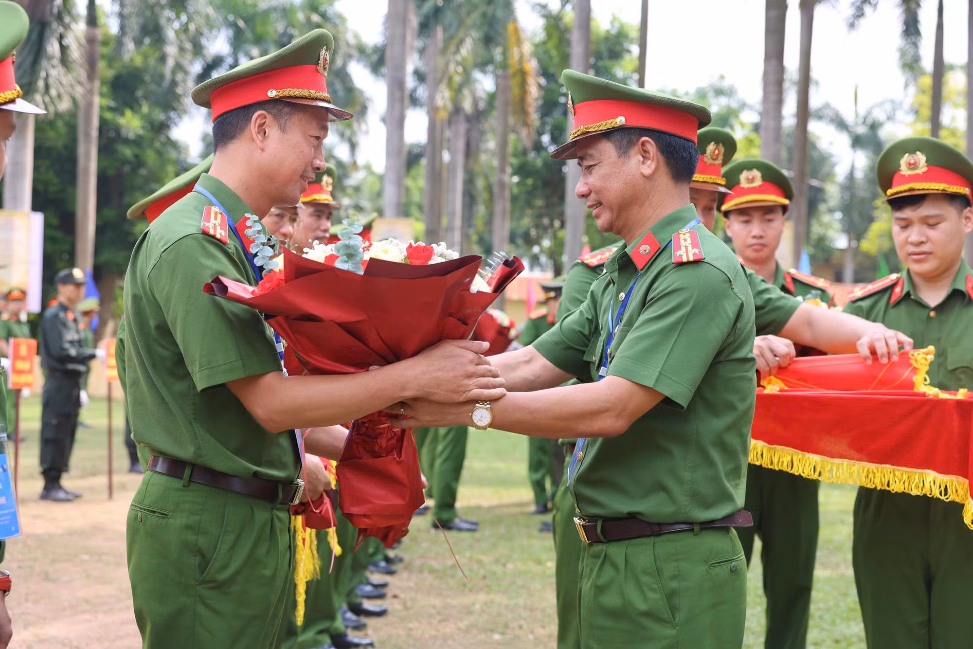 Đại tá Phạm Hữu Thinh tặng hoa chúc mừng đại diện các đoàn tham gia hội thi.