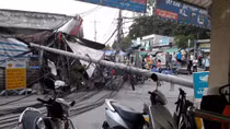 Cột điện ngã đè tiệm sửa xe, chắn ngang đường