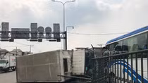 Sụp ổ gà, xe tải tông dải phân cách lật ngang rồi va chạm với xe khách