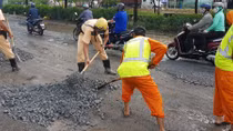 CSGT lấp đá khắc phục đường ổ gà, ổ voi