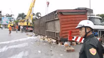 Xe container lật, hàng ngàn thùng sữa ‘lăn’ trên đường