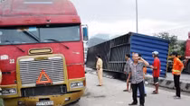 Xe đầu kéo cuốn 40m dải phân cách, lật thùng container xuống đường