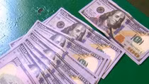 Người đàn ông bán vé số tàng trữ nhiều USD giả