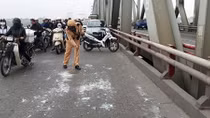 CSGT dọn thủy tinh rơi vãi trên cầu giúp ngườidân tránh nguy hiểm 
