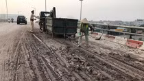 CSGT dọn bùn đất rơi vãi trên đường 