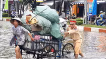 Cảnh sát giao thông giúp dân qua những đoạn đường ngập sâu 