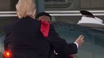 Ông Trump nhặt mũ và đội trở lại đầu binh sĩ