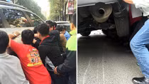 Người dân chung sức nâng ô tô cứu cháu bé mắc kẹt