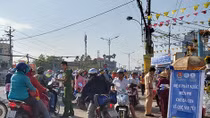 Công an Tiền Giang phát nước suối cho bà con về quê vui tết