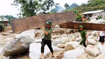 Cán bộ Công an dầm mình trong mưa giúp dân vùng lũ