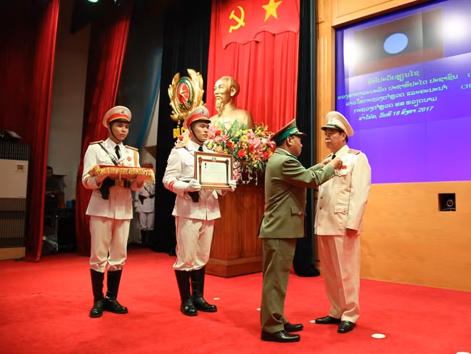 Trung tướng Somkeo Silavong, Bộ trưởng Bộ An ninh Lào gắn Huân chương Lao động hạng Nhì cho Thượng tướng Bùi Văn Nam, Thứ trưởng Bộ Công an Việt Nam.