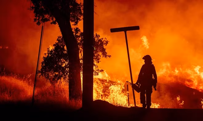 Một người lính cứu hỏa đi ra từ đám cháy rừng ở California, Mỹ. Ảnh: Reuters