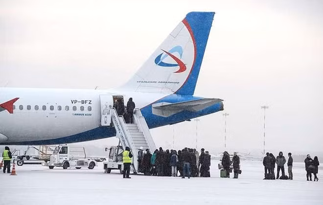 Hành khách di chuyển lên máy bay bằng xe thang ở sân bay Barnaul. Ảnh: TASS